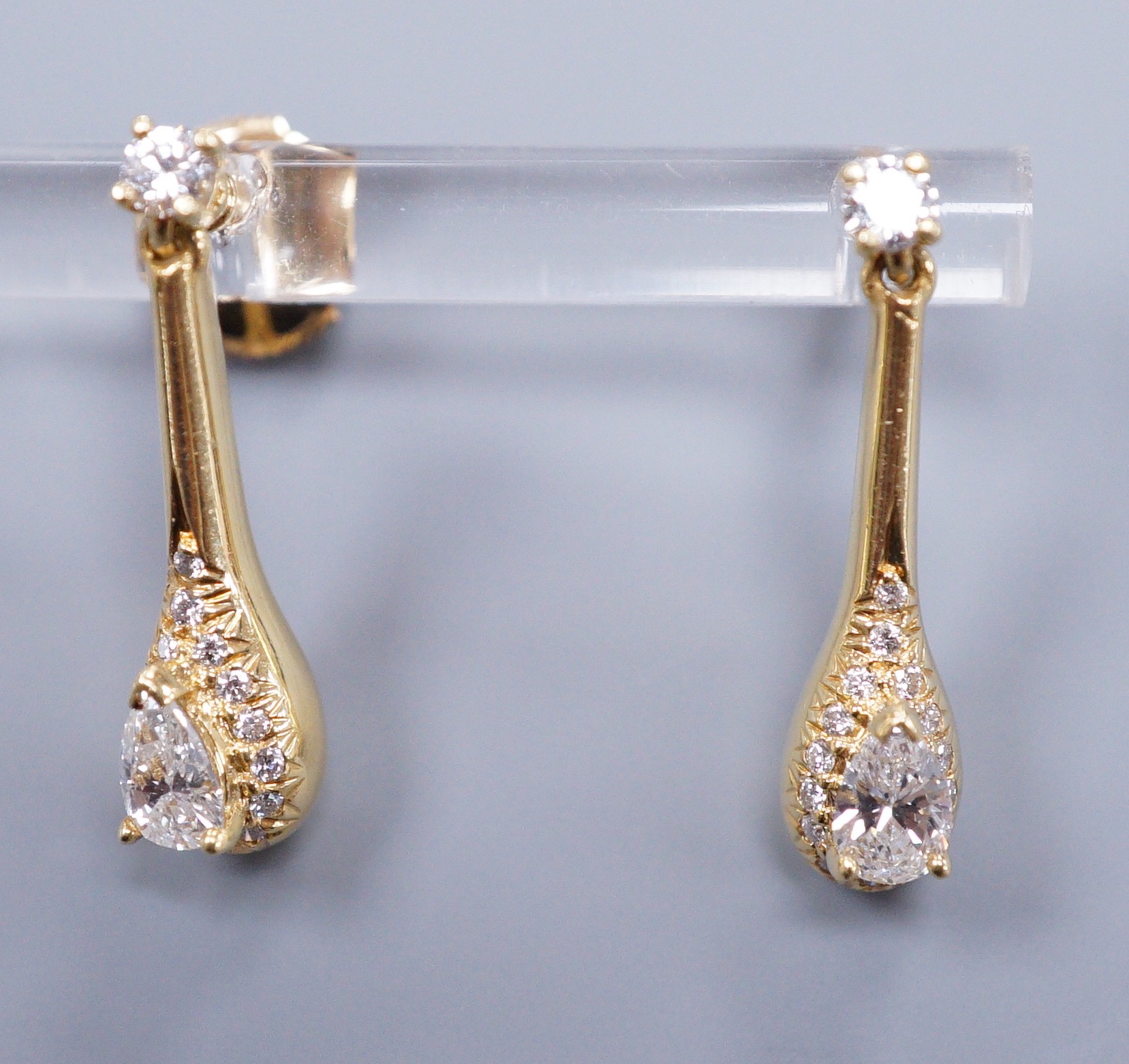 A pair of 18ct gold and diamond drop ear studs, each set with a tear shaped diamond within a border of brilliants, gross weight 5.3 grams